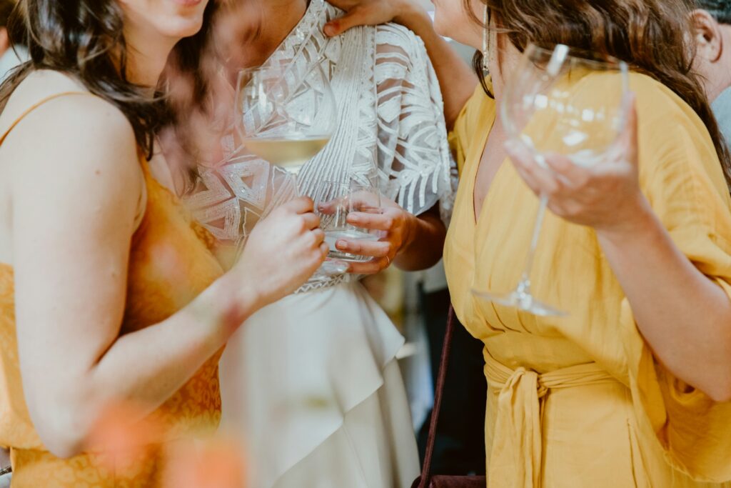 Three women holding glasses at a party