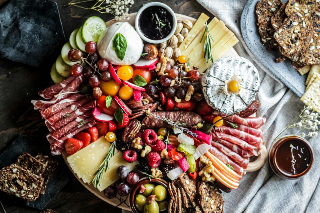 A charcuterie board featuring cheese, meat and fruit.