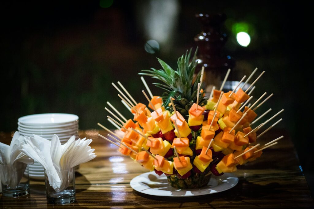 Fruit skewers arranged on a pineapple.