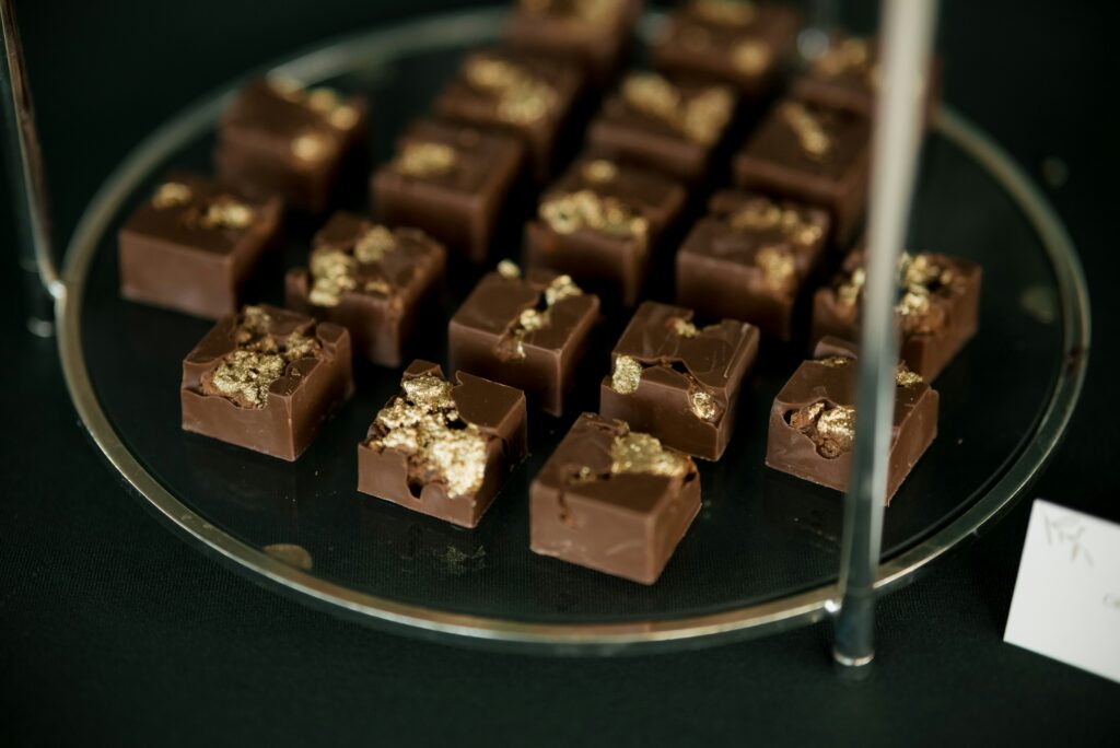 A tray of chocolate squares decorated with gold leaf.