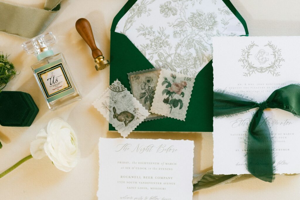 A stamp, green envelope and wedding invitation wrapped in green ribbon