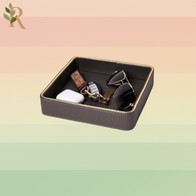 A brown leather tray with sunglasses, keys and air pods inside