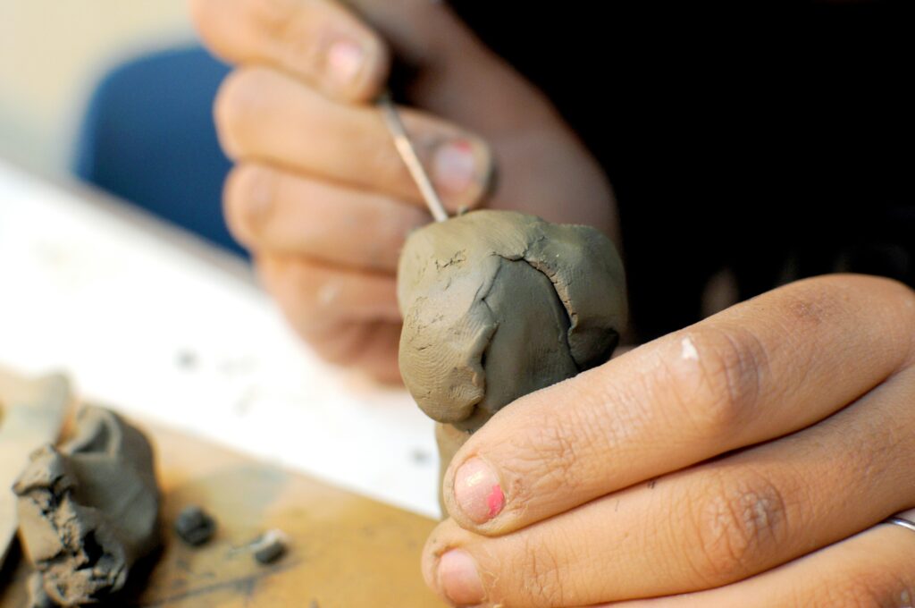 A person carving polymer clay