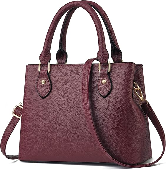 A burgundy crossbody purse sits against a white background. It's square with gold metallic accents.