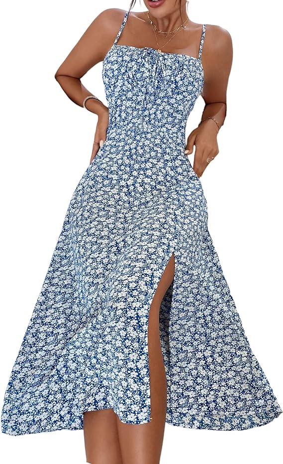 A woman stands in a light blue floral midi sundress with spaghetti straps and a thigh-high slit.