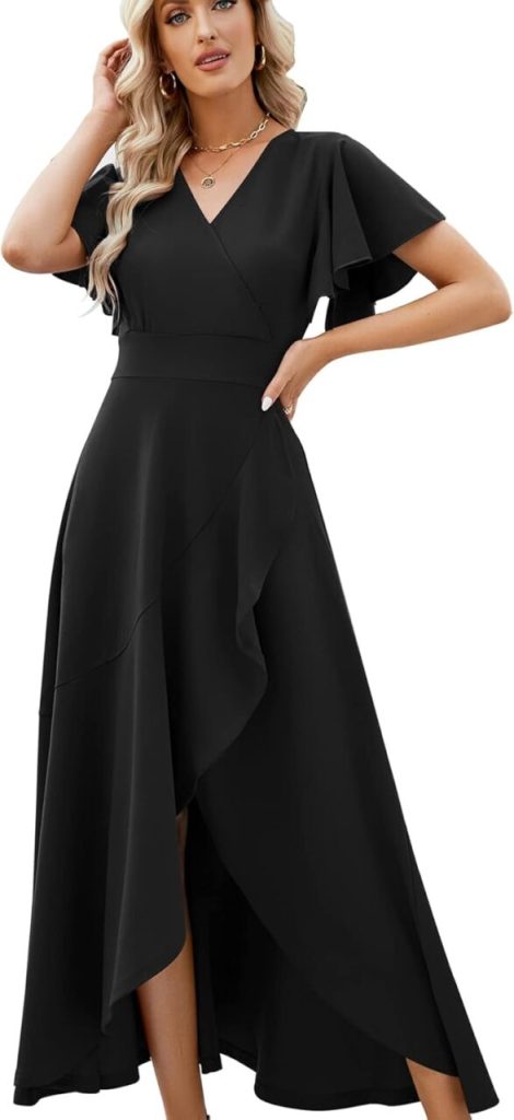 A woman stands in an ankle-length short-sleeved rehearsal dinner dress that's black and has rippling edges.