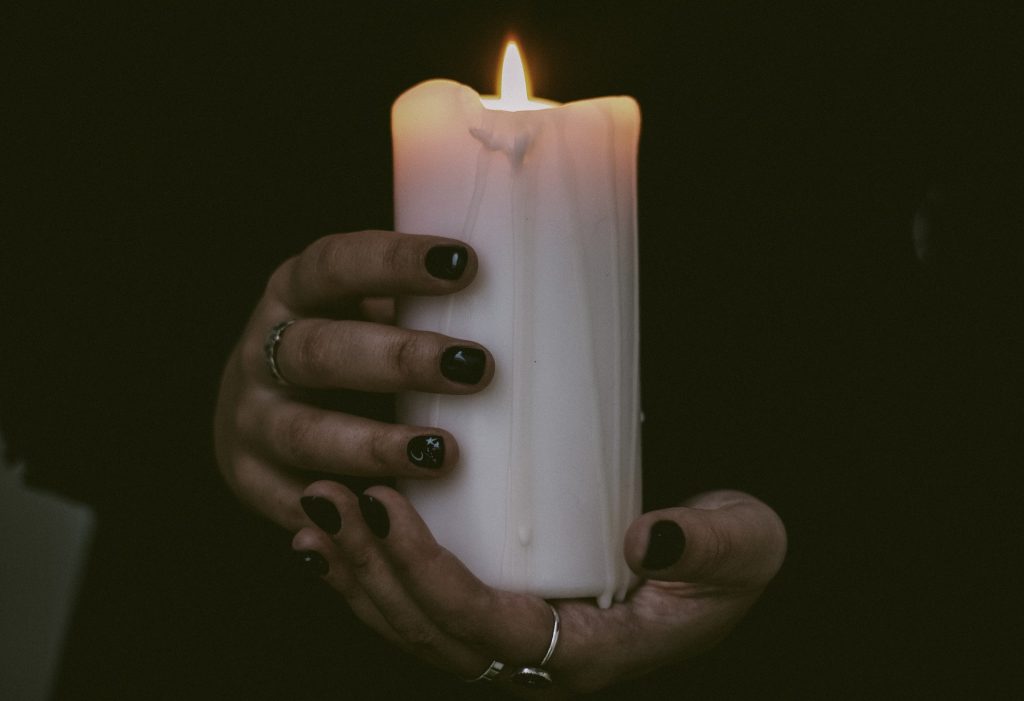 A person holding a white candle