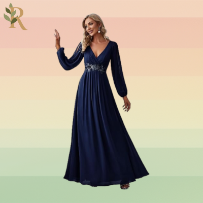 A woman stands in a navy floor-length gown with floral sequins around the waistband. The dress has long-sleeves but they connect at the elbows and wrists, exposing the length of the woman's arms in an elegant style.