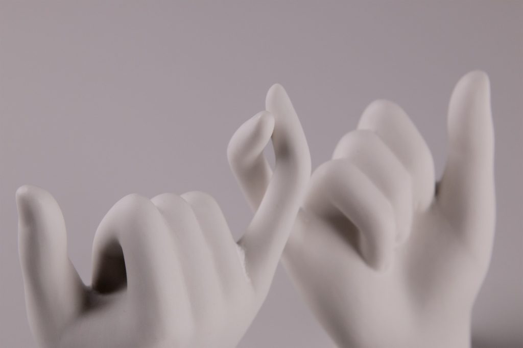Two casted hands touching.