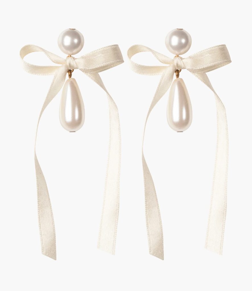 Earrings featuring cream ribbon bows and two pearls.