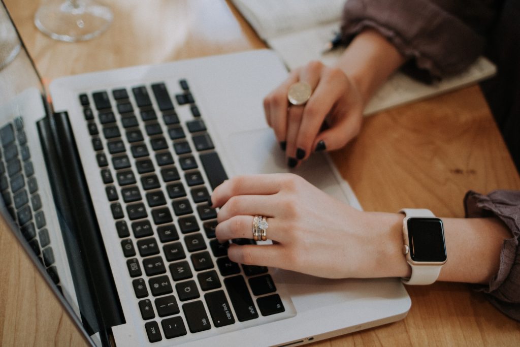 A woman types on a laptop.