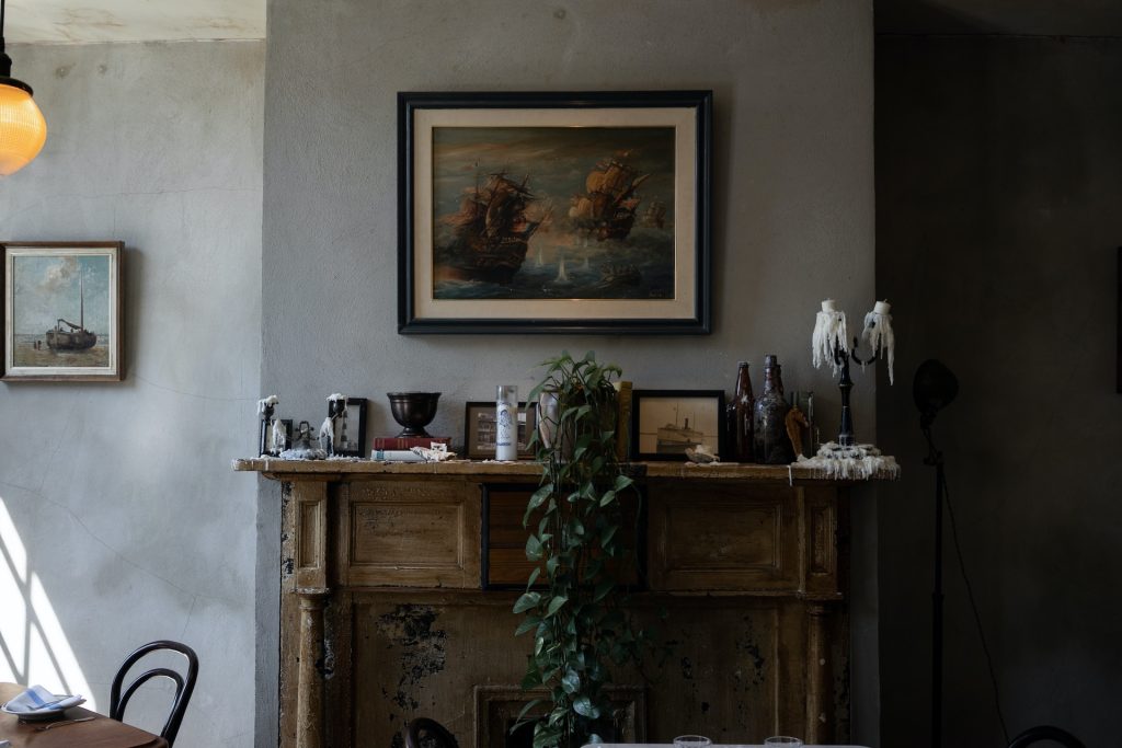 A variety of decor pieces sit on a fireplace mantle.