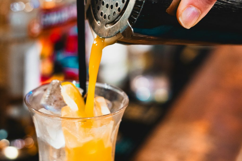 A bartender straining a drink.