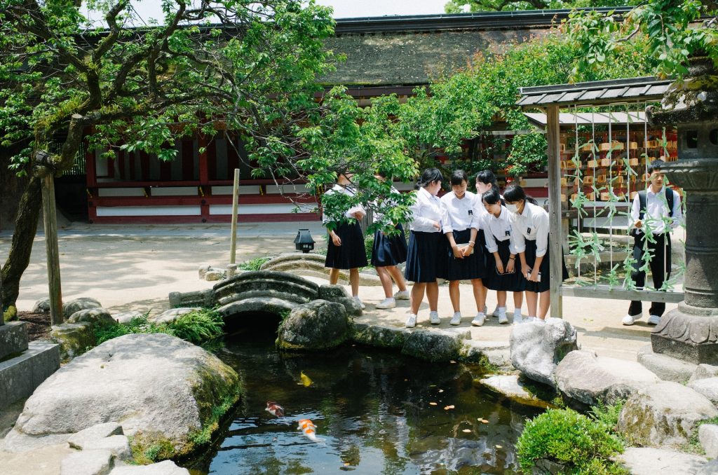 Children look down into a koi pond.