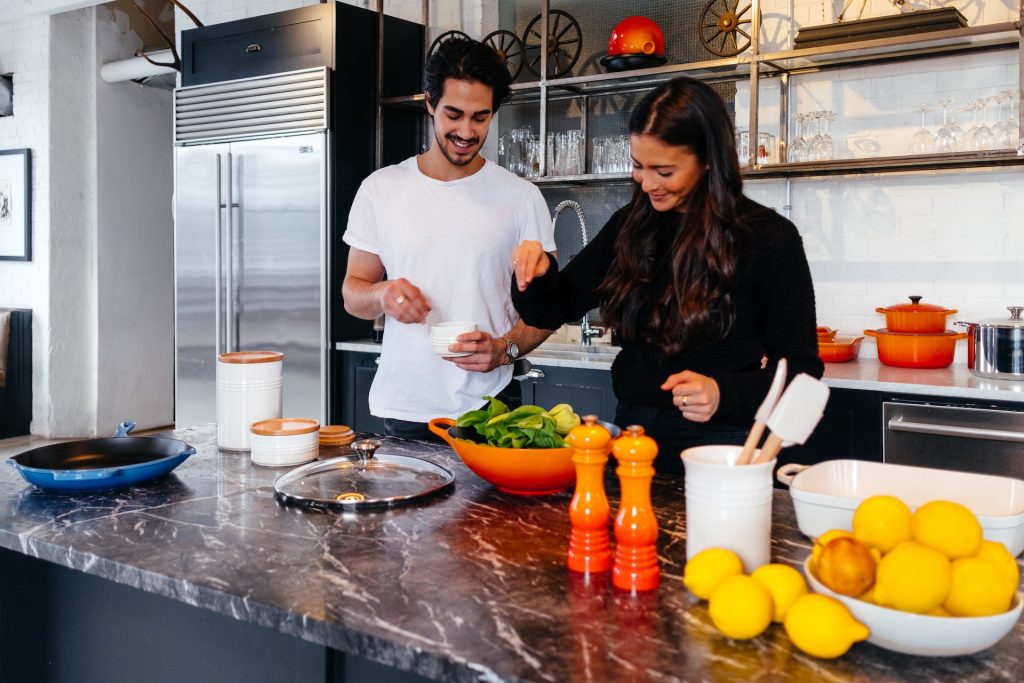 A couple cooks together.