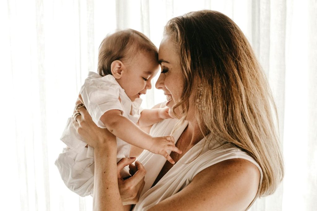 A mother nose to nose with her smiling baby.