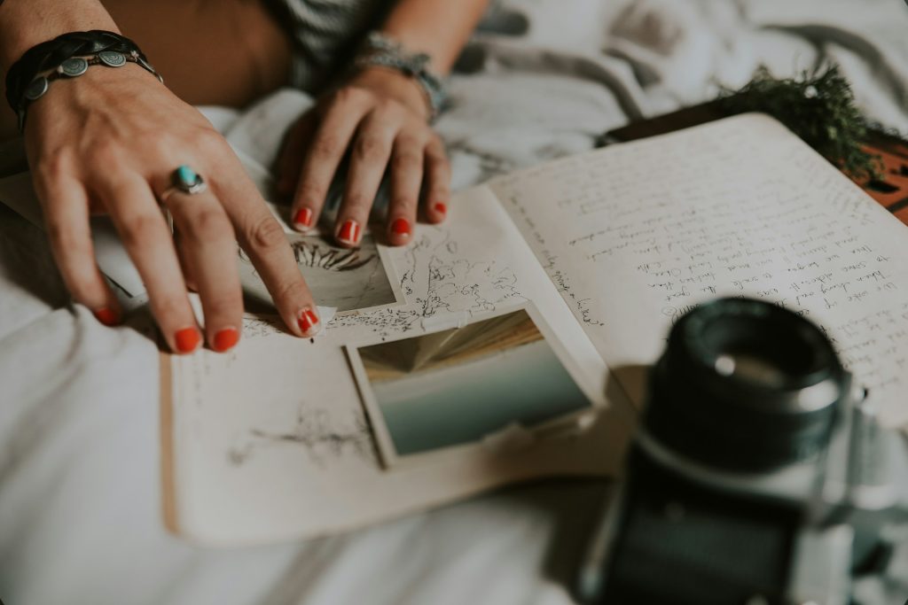 A woman tapes photos into a journal.