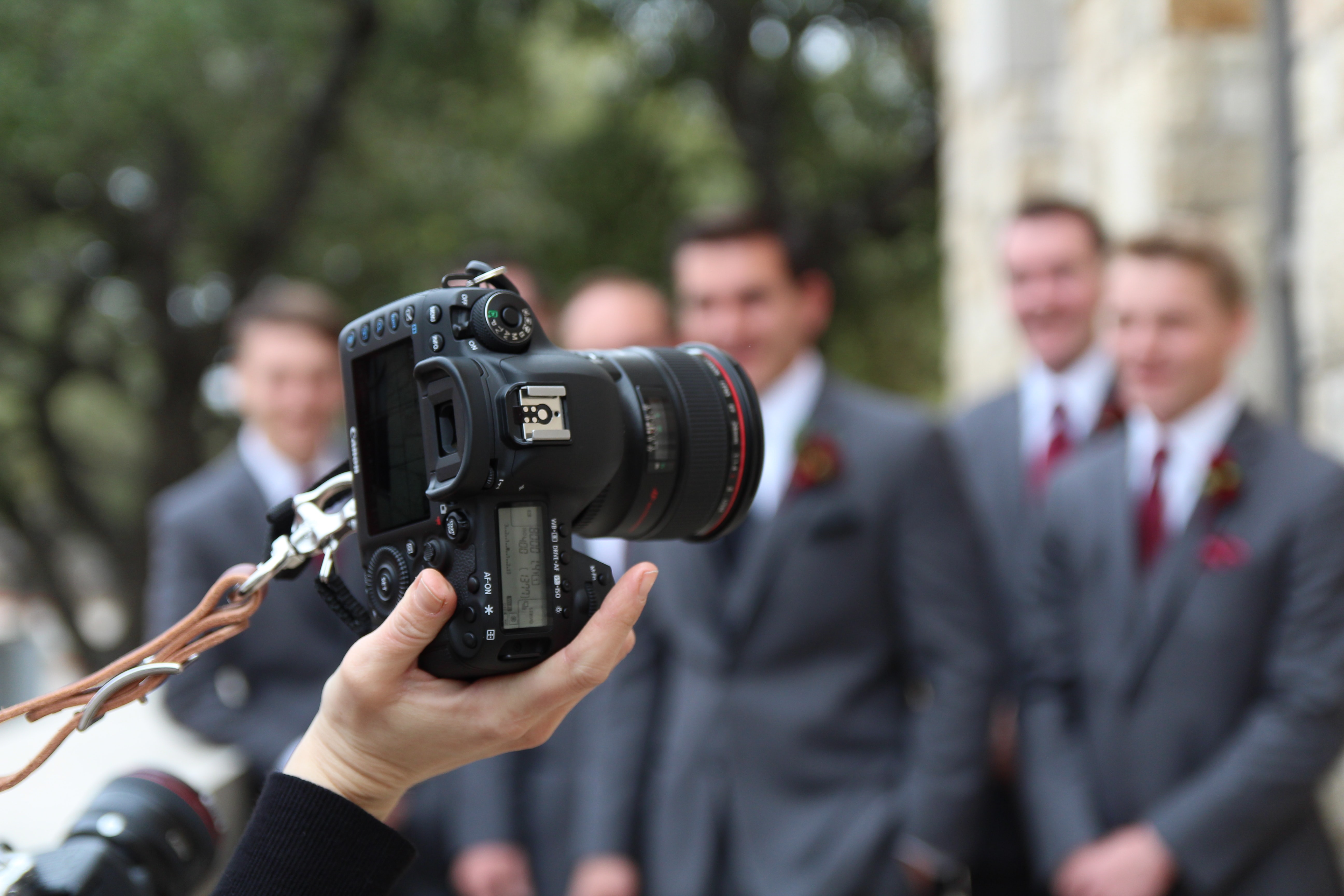 A photographer takes a photo of groomsmen.