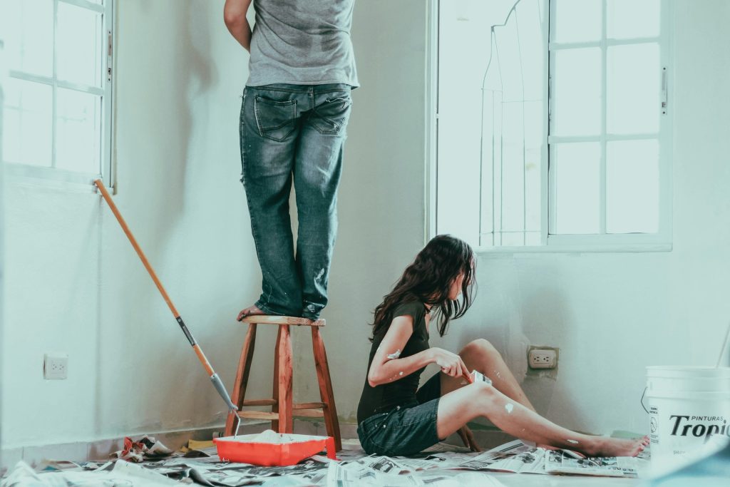 A man and woman paint a room.