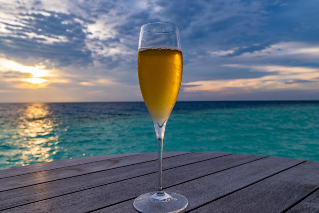 wine glass on deck in front of water