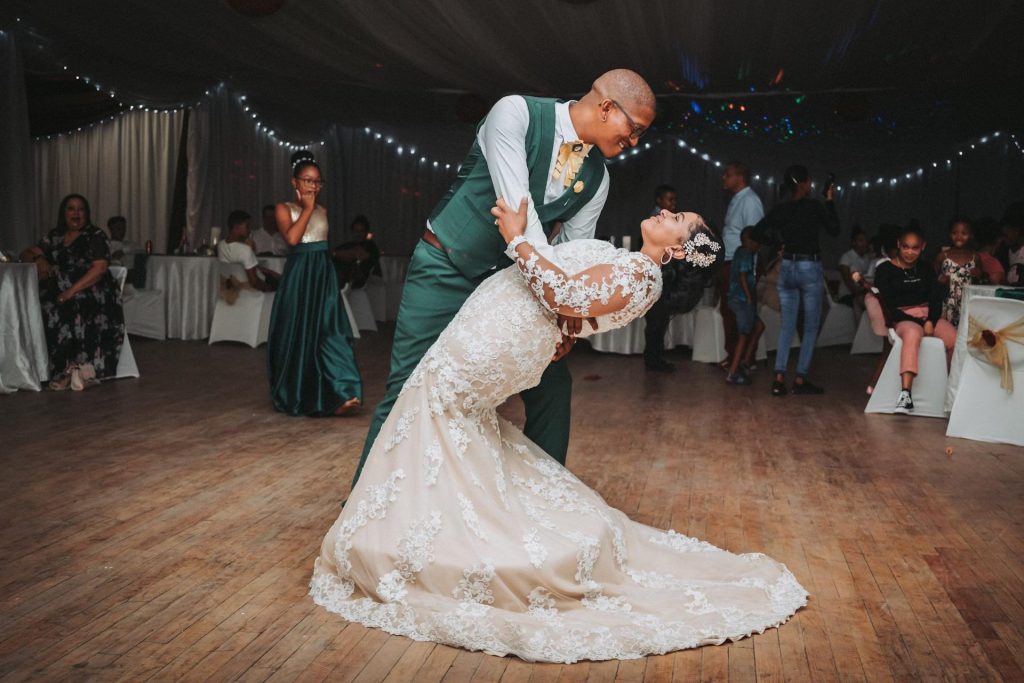 groom in green dancing with bride in white