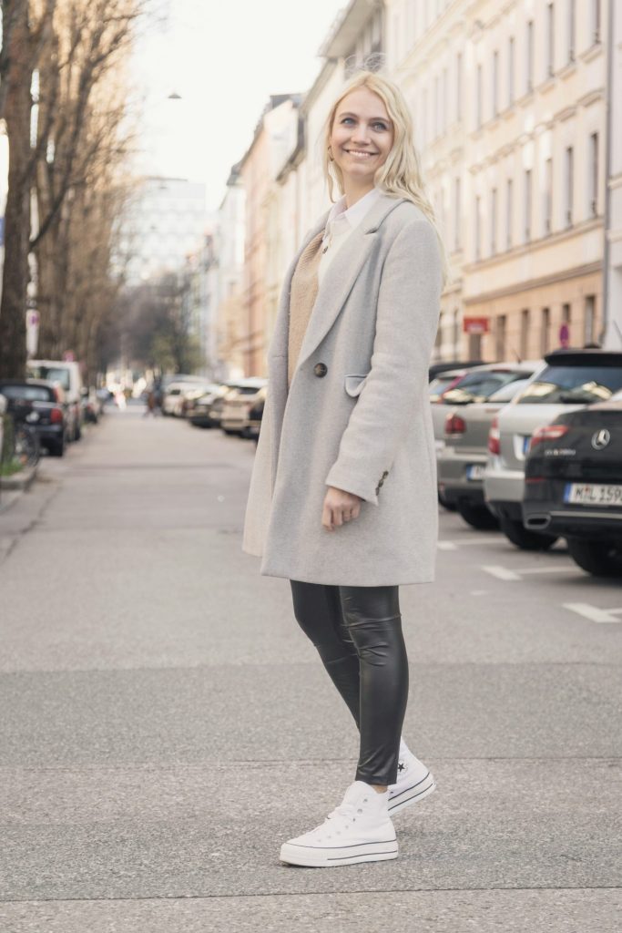 A girl standing and smiling in the street