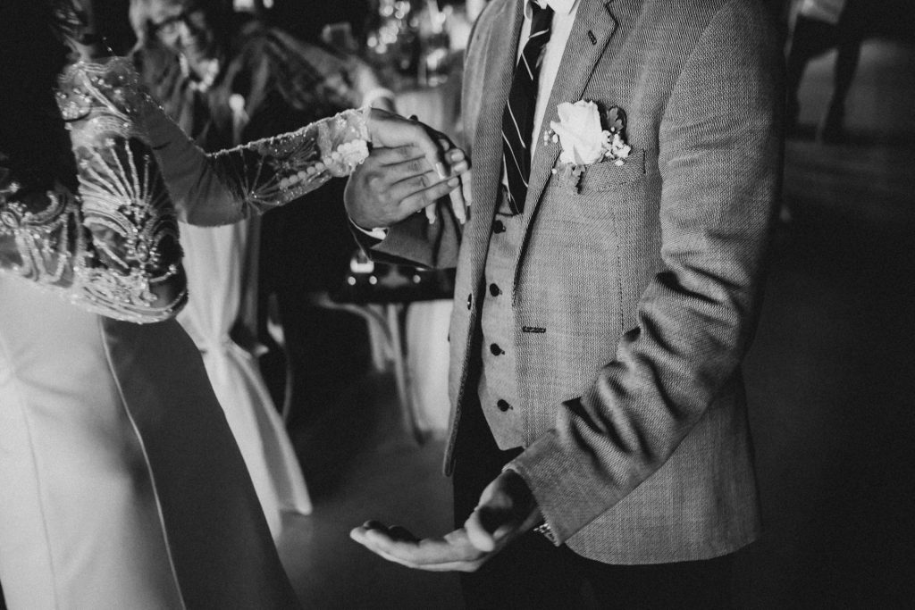 Grayscale image of a groom wearing a three-piece suit.