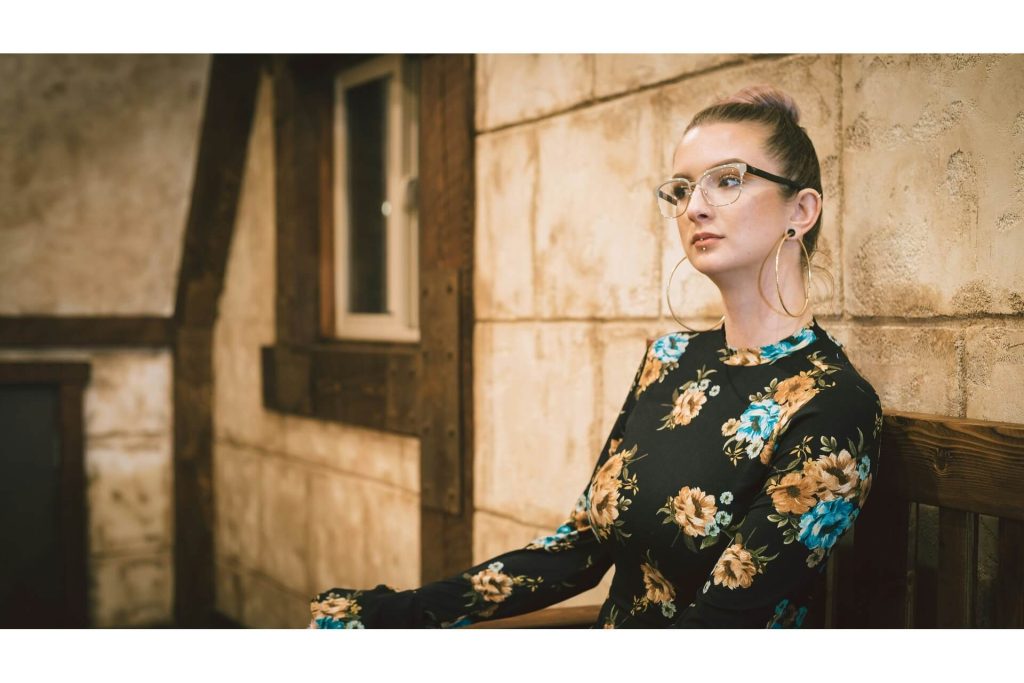 A woman with gold hoop earrings and a silver labret piercing.