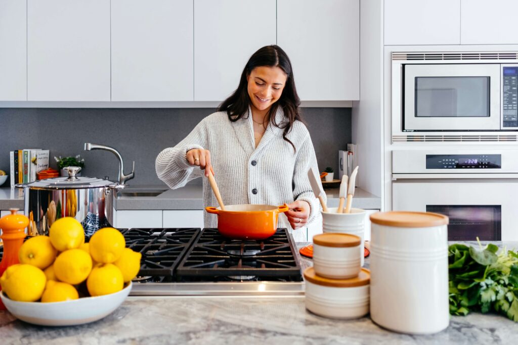 A woman happily cooking in her home