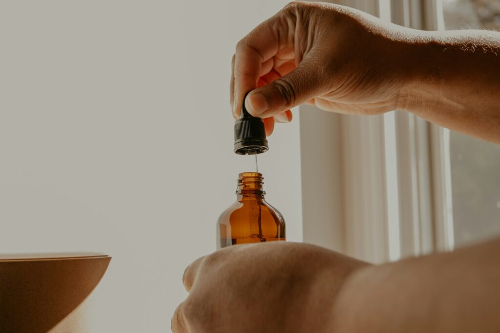 A hand holding a scalp tonic bottle