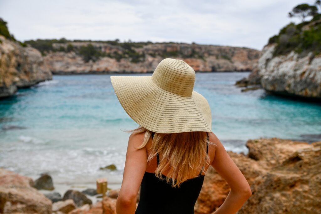 a girl exploring the beach wearing a sun hat