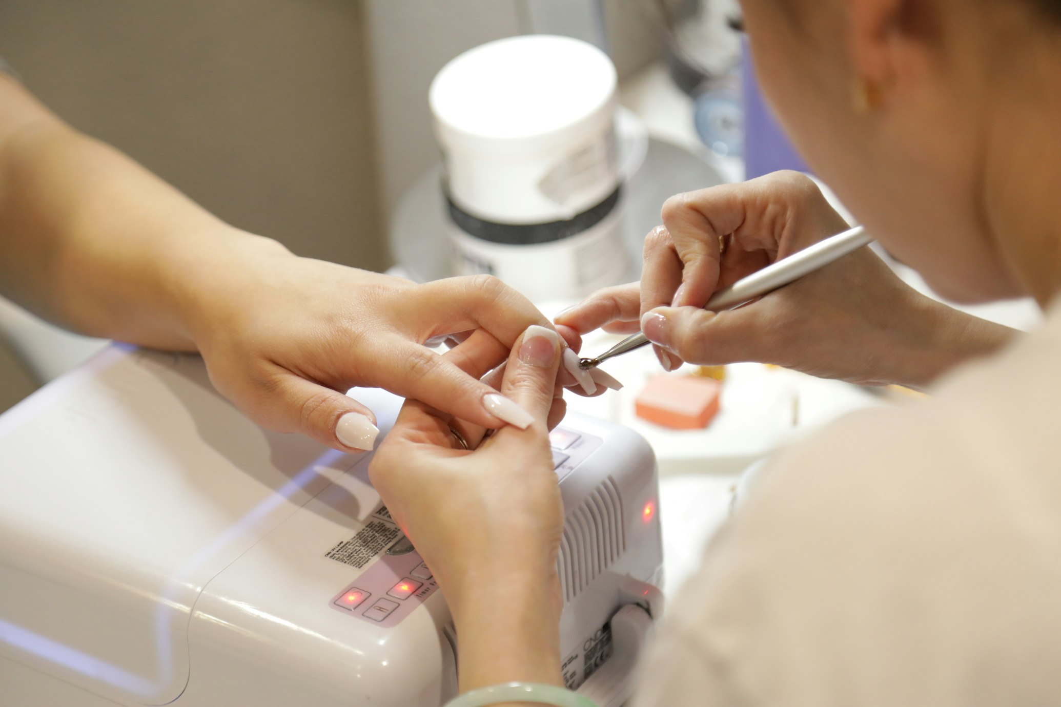 A nail tech polishing the nails