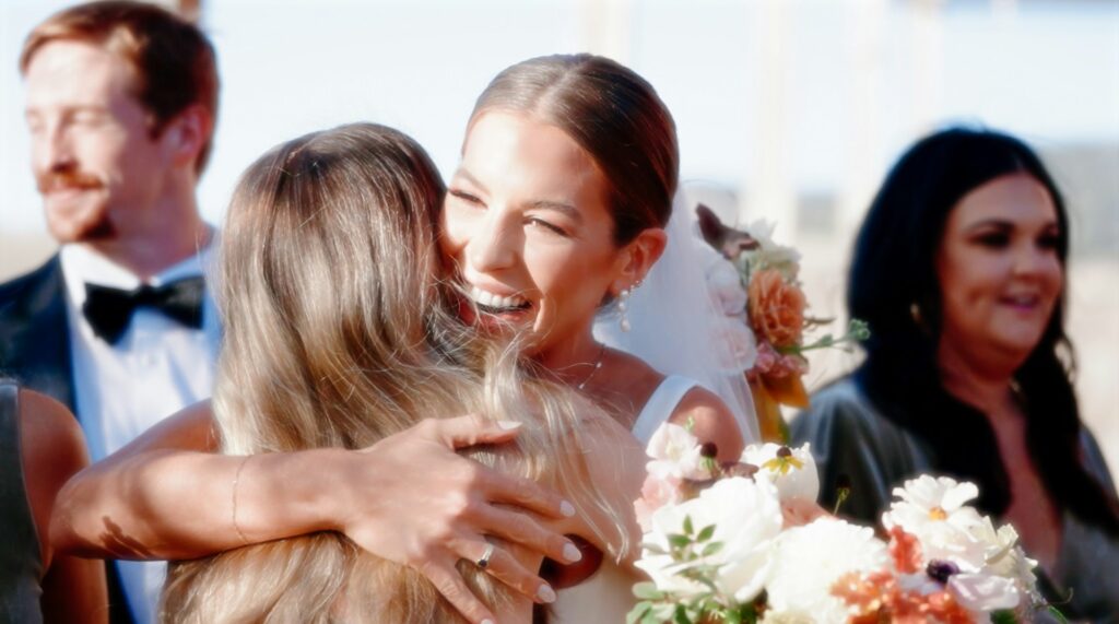 bride hugging female guest at a wedding