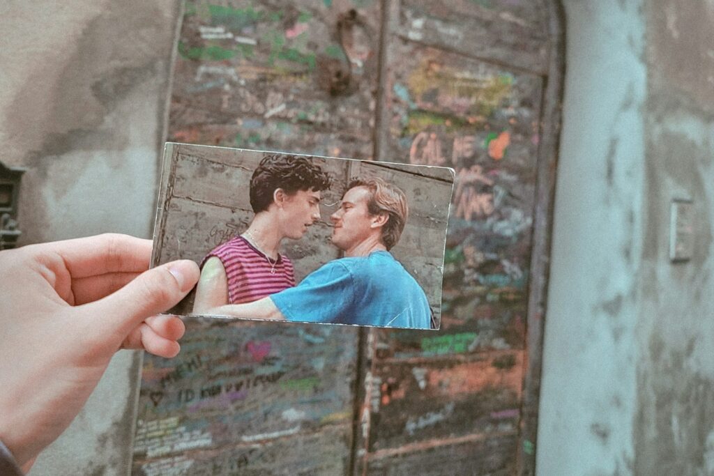 A person in Crema Italy, holding a printed image of a scene from Call Me By Your Name