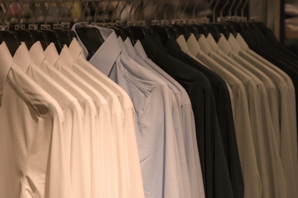 A rack displaying various shirts in a well-lit room, showcasing different colors and styles.
