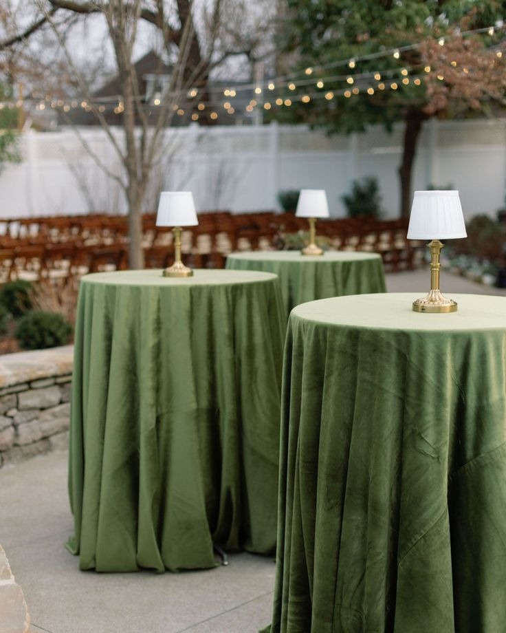 High top tables with green cloth and lamps outdoor wedding venue