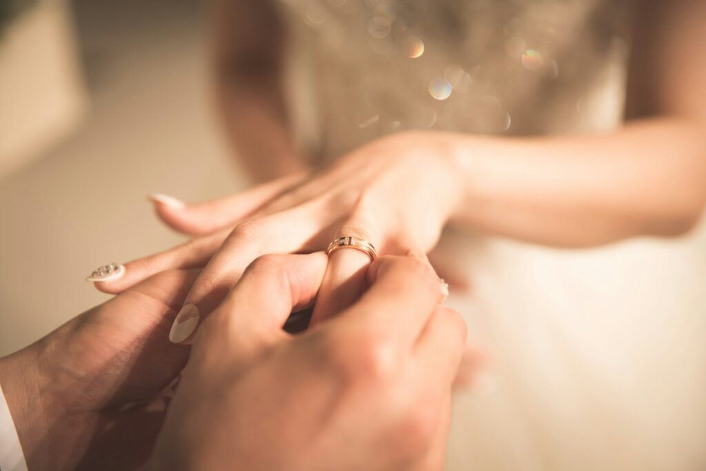 man putting ring on woman hand