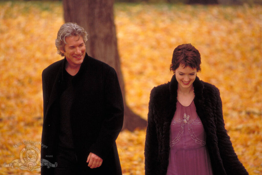 The two main characters from Autumn in New York surrounded by autumn leaves
