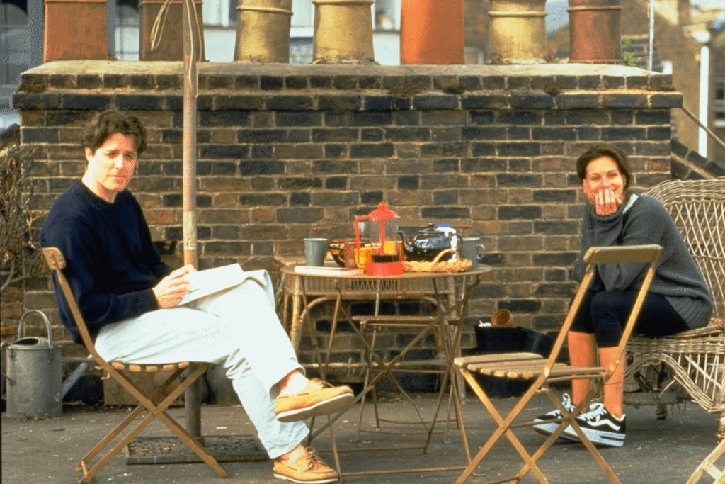 The two main love interests from Notting Hill sitting outside having tea together