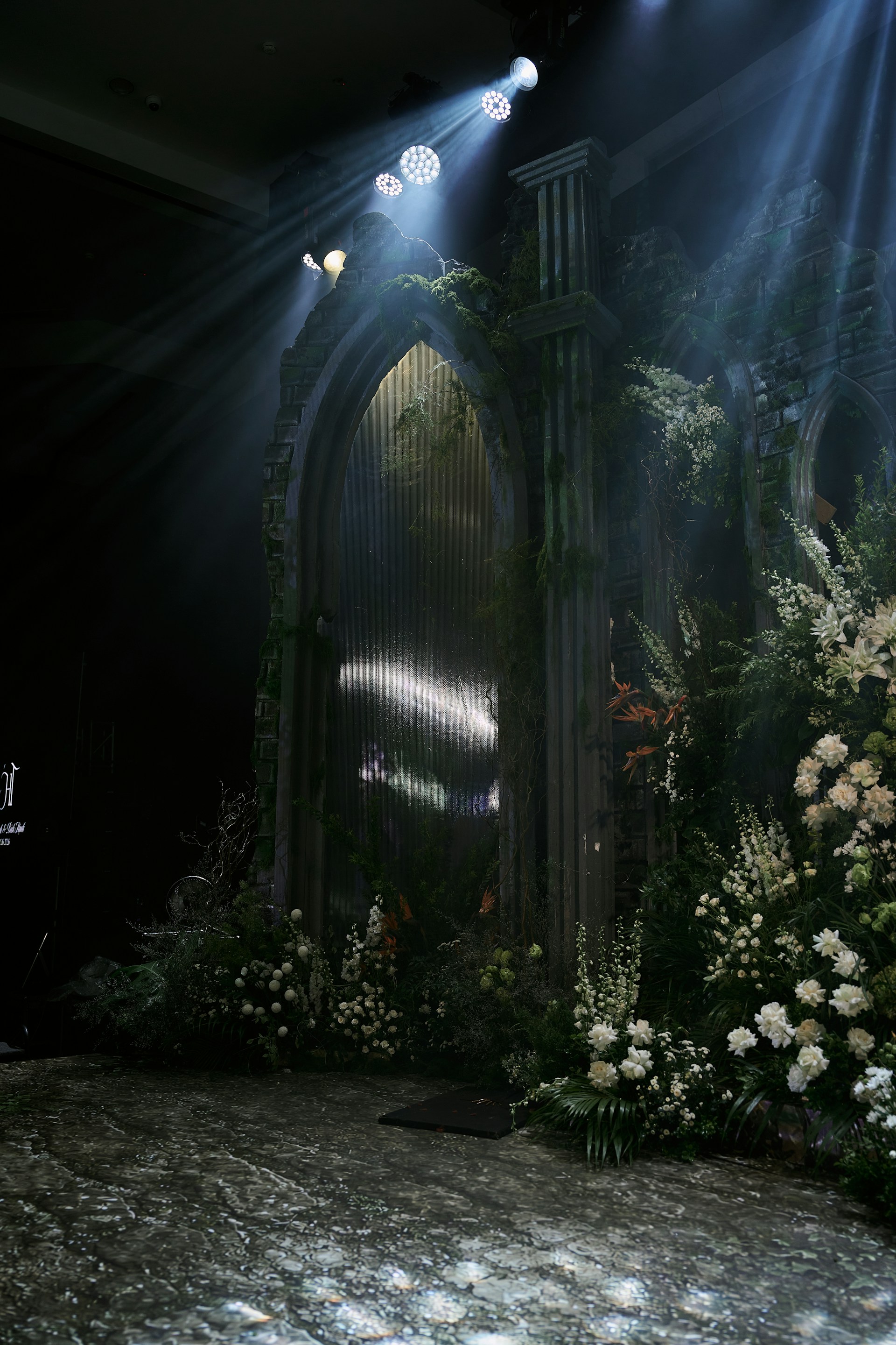 Dark archway lit by spotlights, surrounded by flowers for gothic wedding ideas