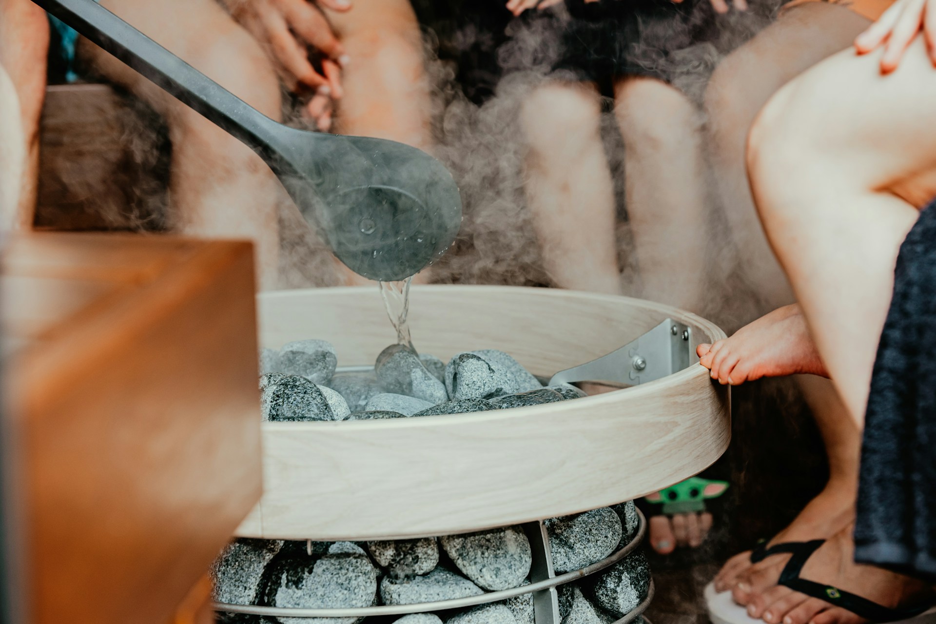 People sitting around sauna stones.