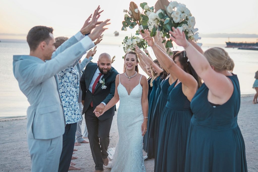 walking under wedding party arms