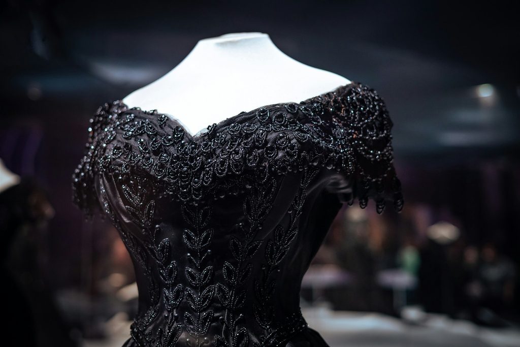Intricate black dress with sequins and lace on mannequin
