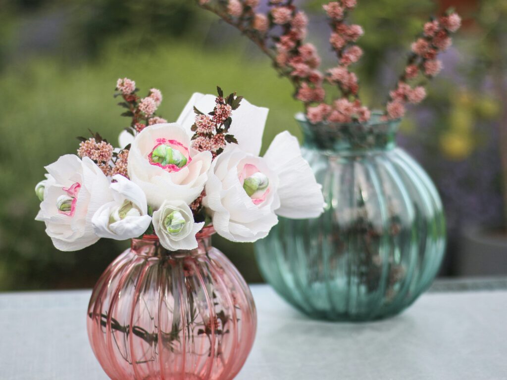 Pink and blue vases with white and pink flowers. 