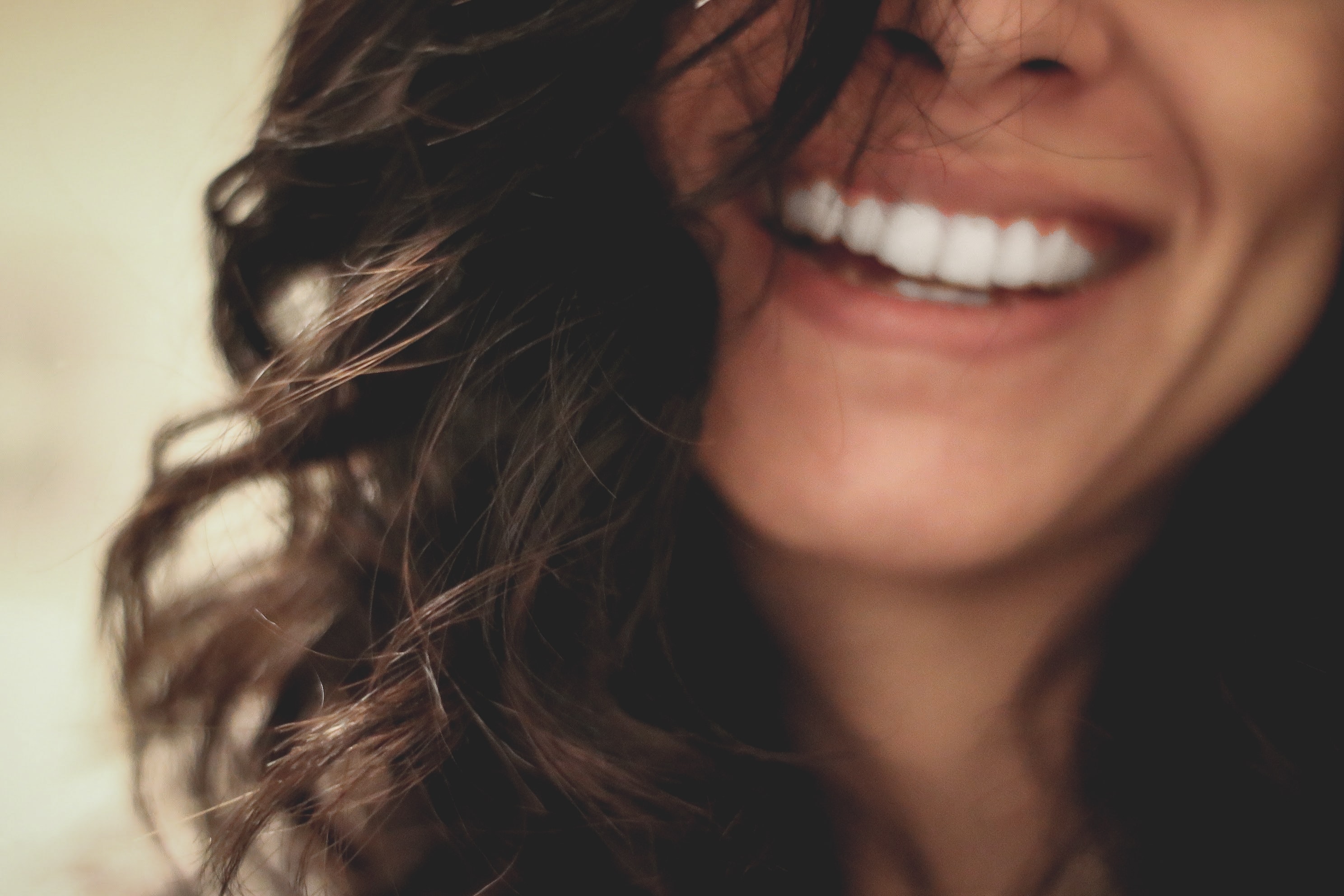 A woman smiles, showing off bright white teeth.
