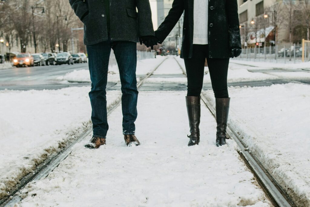 A man and woman standing in the snow. 