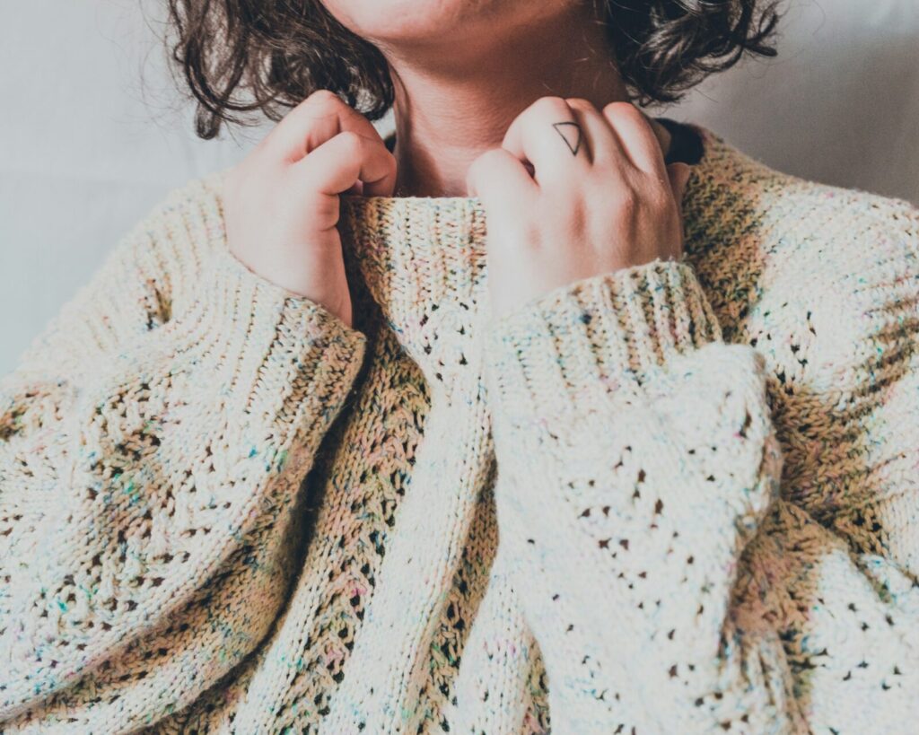 A woman wearing a cream knit sweater.