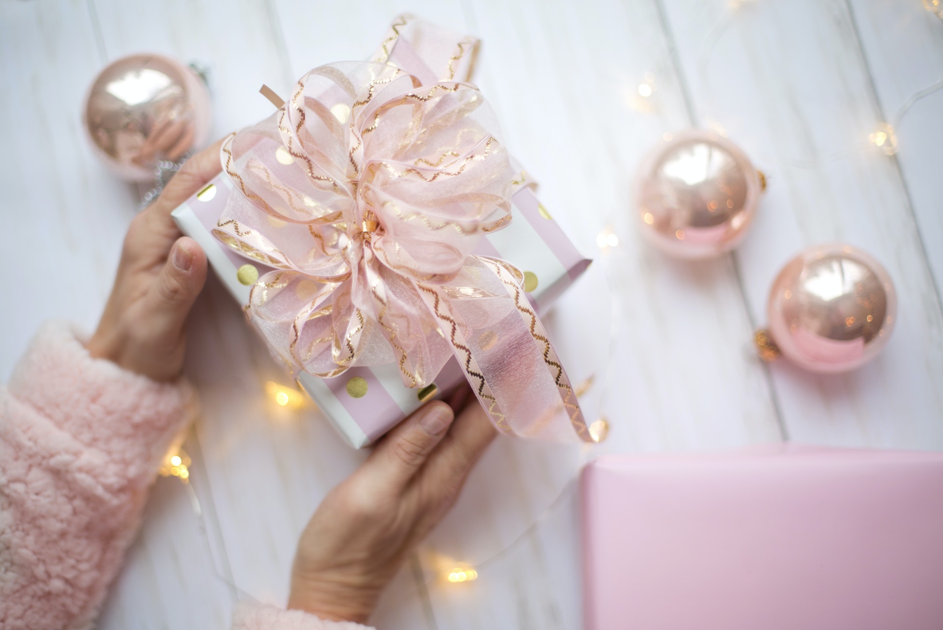 A bridal shower gift is wrapped in silver paper with a pink bow.