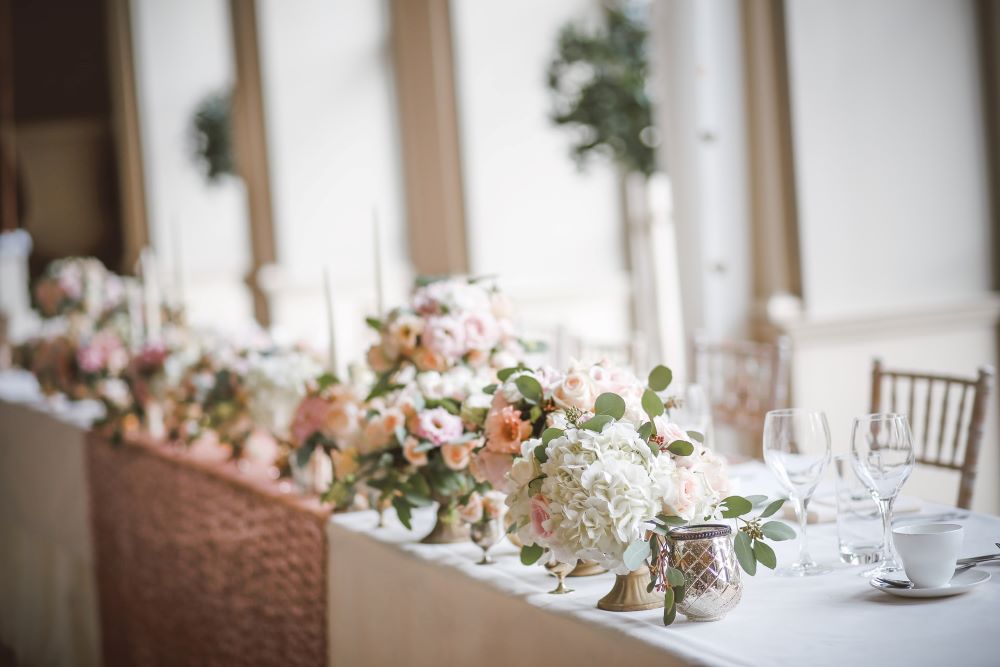silk floral centerpieces at wedding head table to save on average cost of flowers for a wedding