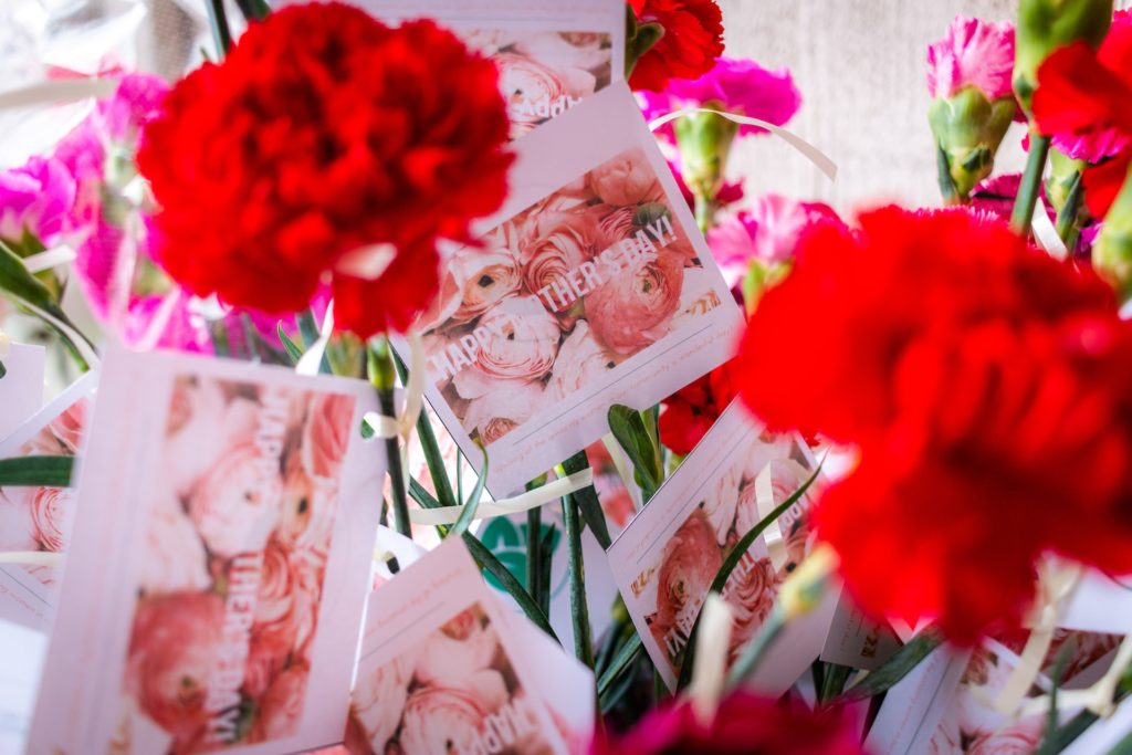 Red and pink carnations with cards reading "Happy Mother's Day."